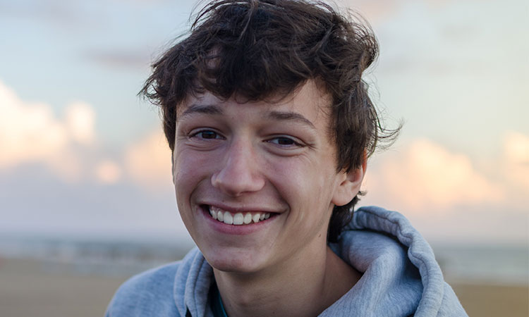 teen boy smiling at the beach