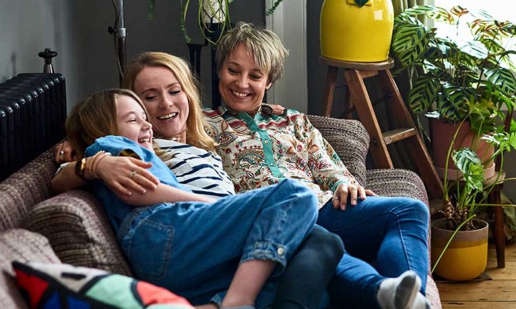 two parents with daughter on couch